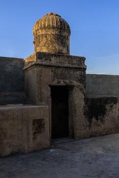View of the historic Serai Chhimba remains on Multan Road, featuring a weathered stone dome and ancient masonry walls under a clear blue sky in Chhimba, Punjab, Pakistan.