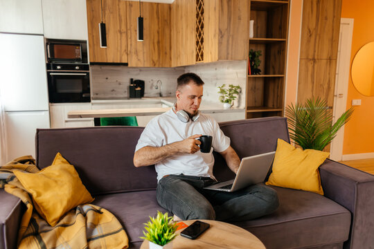 Man work remotely on laptop from home sofa