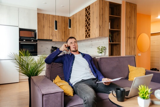 Man working remotely on laptop from home sofa