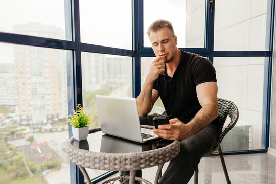 Man manage remote work with laptop on balcony