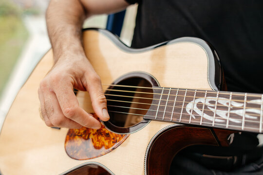 Man play acoustic guitar on balcony