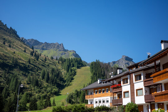 Scenic view of mountains and buildings in a village during a sunny day in the Alps