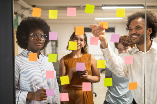 Diverse team planning ideas with sticky notes in office