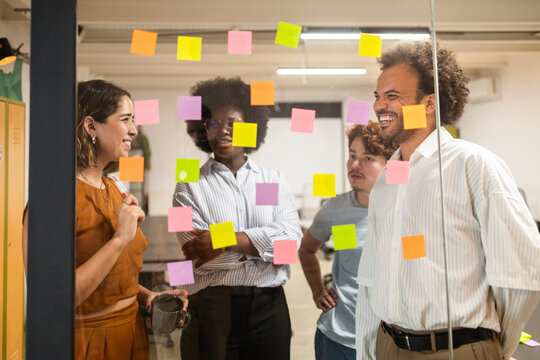 Diverse team brainstorm ideas with sticky notes in office