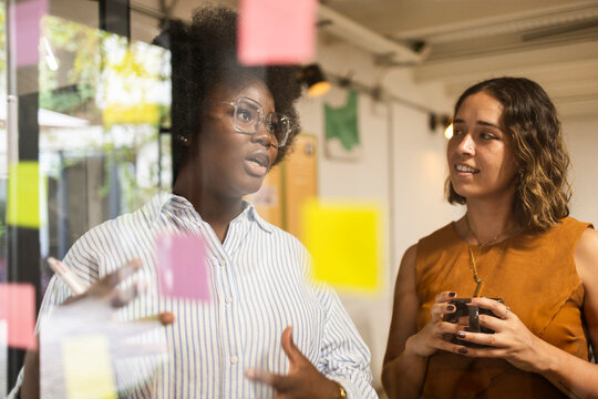 Coworker discuss project ideas in creative office meeting
