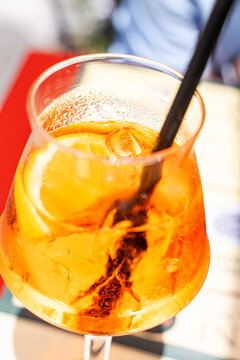Aperol Spritz cocktail with orange slice and black straw