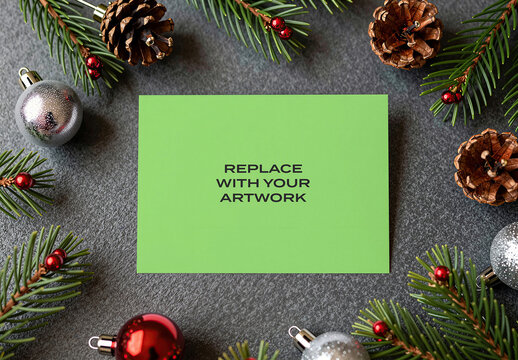 Stationery mockup with Christmas decorations on a dark textured surface, featuring pine branches, pinecones and ornaments, flat lay composition for holiday card or greeting design, Template