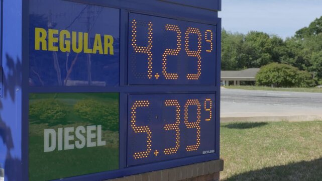 Fuel Prices Displayed at Gas Station in Urban Setting During Day. Price Sign is Symbol of Volatile Energy Market Global Cost of Oil. High Inflation in USA. 
