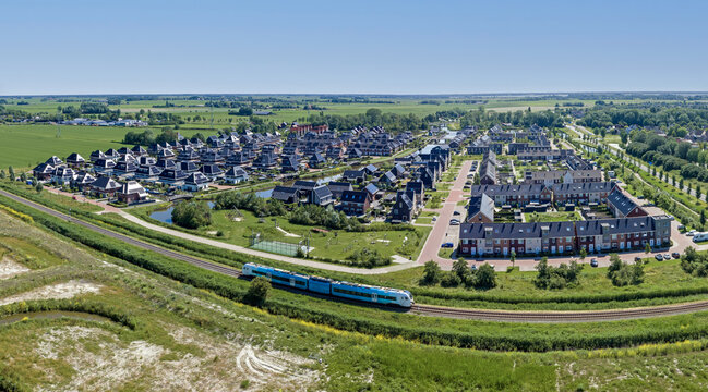 Aerial view of a new residential development with passing train in Europe