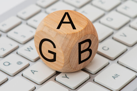 AGB gedruckt auf einem Holzw&uuml;rfel auf einer Computer-Tastatur