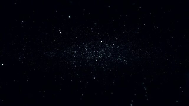 Small glowing particles drift slowly across a dark background, forming a subtle dispersed pattern of light points. Abstract animation features drifting movement and luminous energy.