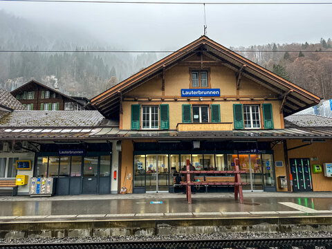 Lauterbrunnen, Switzerland - March 14, 2026. Lauterbrunnen Railway Station Building on a Rainy Day in Switzerland. A wide shot captures the front facade of the historic Lauterbrunnen railway station b