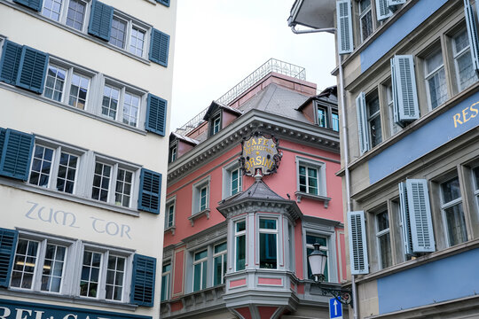Zurich, Switzerland - March 15, 2026. Historic Cafe Restaurant Orsini and Colorful Buildings in Zurich Old Town. A low-angle shot highlights the vibrant, pastel-colored facades of historic buildings i