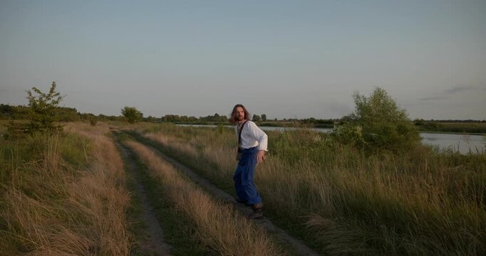 Caucasian man with long hair and Ukrainian traditional folk attire run away being chased . 4K 10-bit