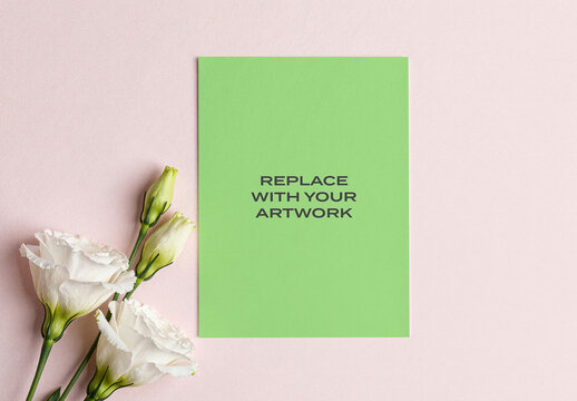 Vertical paper mockup with placeholder text displayed on a pink textured surface, minimalist stationery presentation featuring white lisianthus flowers