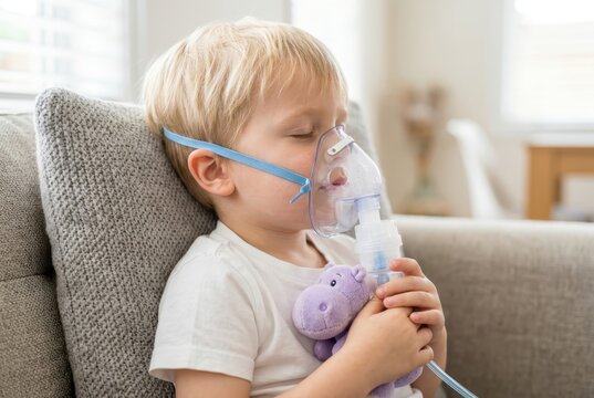 Little Boy Using Nebulizer Inhaler Mask for Asthma Treatment at Home While Holding a Stuffed Toy