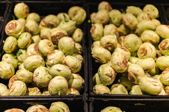 Fresh kohlrabi vegetables stacked in supermarket produce section with organic healthy grocery food display