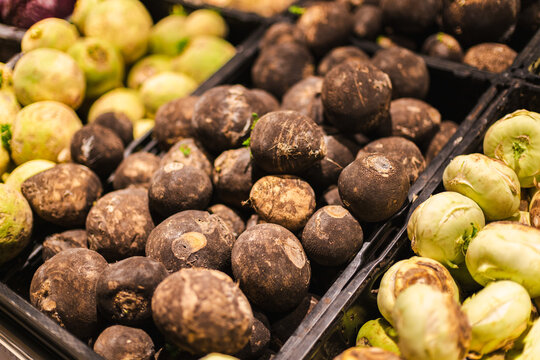 Black radish and kohlrabi vegetables displayed in supermarket produce section with fresh organic grocery selection