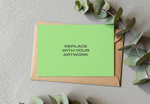Stationery mockup with brown envelope and eucalyptus branch on a textured surface, flat lay top view presentation for graphic design, branding, advertising, print display, template