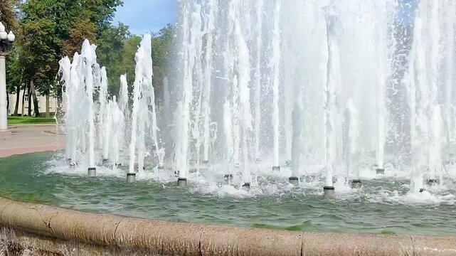 Public park fountain spraying tall streams of water, showing changing jets and urban recreation scenery in a dynamic outdoor landmark sequence