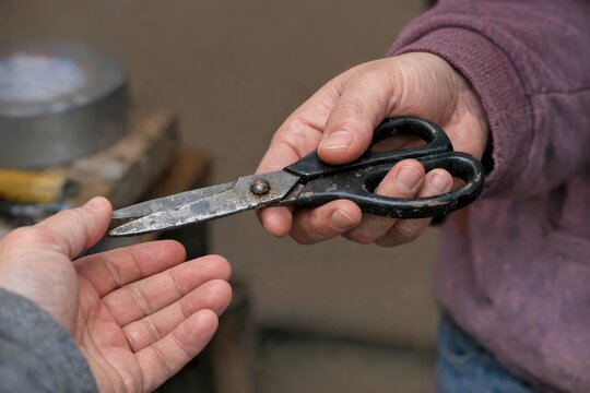 A person holds a pair of scissors in their hands