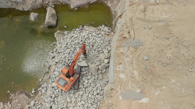 Aerial View of Excavator Working Beside Quarry Water