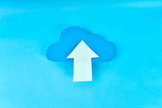 Blue cloud with large white upload arrow on bright blue background, cloud storage concept
