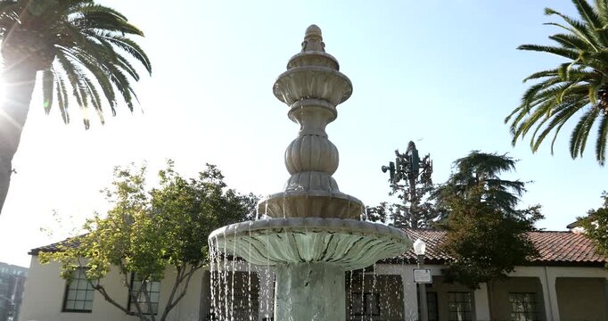Afternoon sun shines on historic buildings and fountain in downtown Azusa, California, USA. 