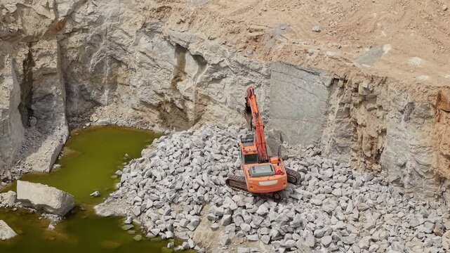 Excavator Working at Bottom of Deep Stone Quarry