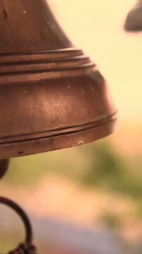Close Up of Weathered Bronze Bells Being Rung