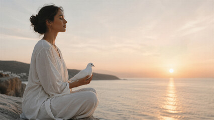 Fototapeta premium Woman holding a white dove beside the sea at sunset. Symbol of peace, freedom, hope, harmony, and compassion for International Day of Peace concept
