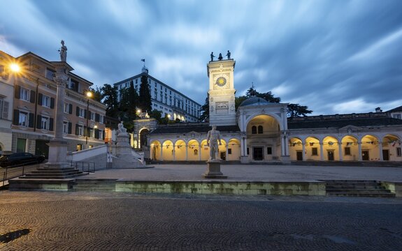 Illuminated main square Piazza della Libert&agrave; with Loggia e Tempietto di San Giovanni and clock tower, Castello di Udine behind, blue hour, dramatic sky, old town, Udine, Friuli-Venezia Giulia, Italy