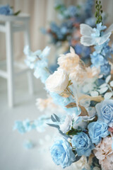 Fototapeta premium Light blue and pastel pink floral arrangement with decorative butterfly wings on light background