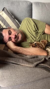 Close-up of a tired mature man sleeping peacefully on a comfortable couch, taking a relaxing siesta in a calm and tranquil environment, showcasing a moment of rest and rejuvenation