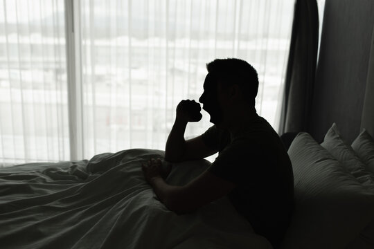 Young man waking up in the morning feeling tired suffering from insomnia bad sleep	