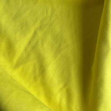Yellow fabric texture with wrinkled folds close up