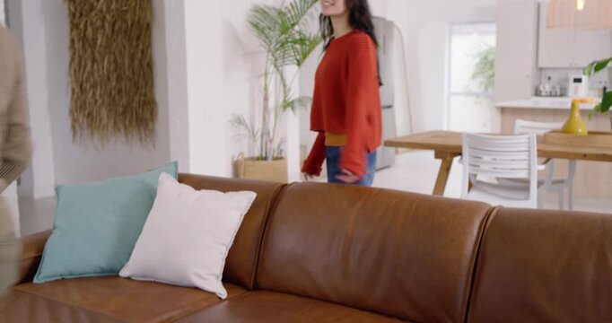 Couple reacting as woman entering causing man ending phone call to greet, moving to kitchen island