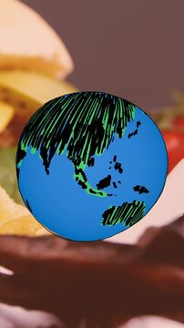 Animation of globe icon over fast food with hamburger, chips and onion rings