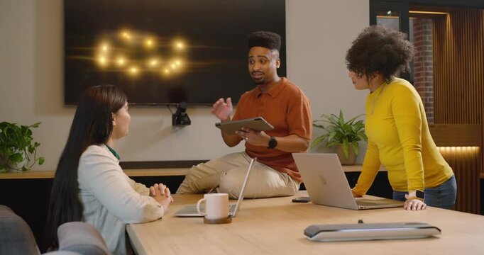 African American colleagues meeting in office, man tapping tablet, revealing data to review project