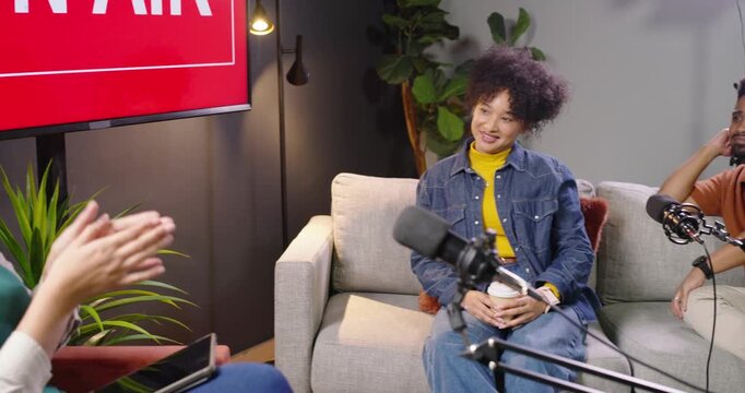 African American guests reacting to host gesturing, grabbing mic, joining discussion in studio