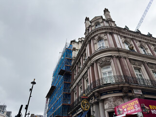 Fototapeta premium Historic Victorian corner building with scaffolding and signage in Spring Gardens, London, UK on overcast day
