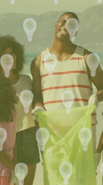 Animation of lightbulb icons over african american family segregating waste