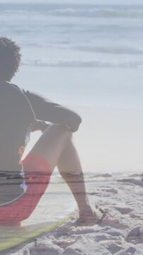 Animation of happy african american couple with surfboards on beach