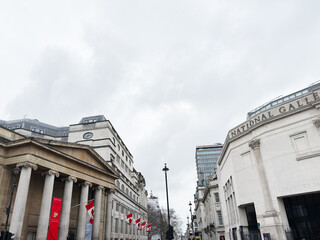 Fototapeta premium People walking past the National Gallery and Sainsbury Wing on a cloudy day in London, UK