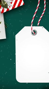Animation of christmas tag with copy space, decorations and snow falling on green background