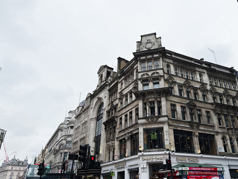 Historic stone building and Wardour street corner with Shake Shack in London, UK city centre