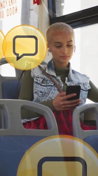 Animation of social media icons over woman sitting in bus and using smartphone