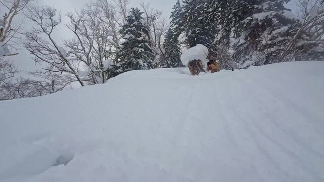Professional snowboarder jumping off a natural kicker in deep powder