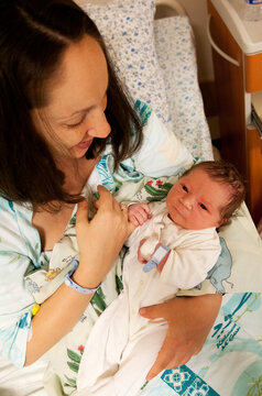 Mother and her newborn baby boy in bed in hospital. Shot from above
