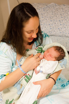 Mother and her newborn baby boy in bed in hospital